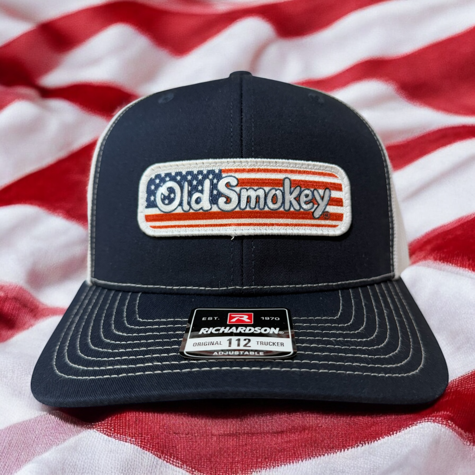 An American Flag Old Smokey logo hat sitting on an American Flag