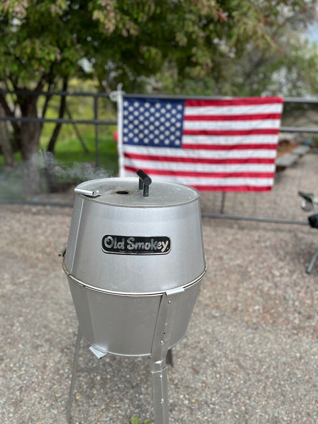 An Old Smokey Charcoal Grill with an American Flag behind it