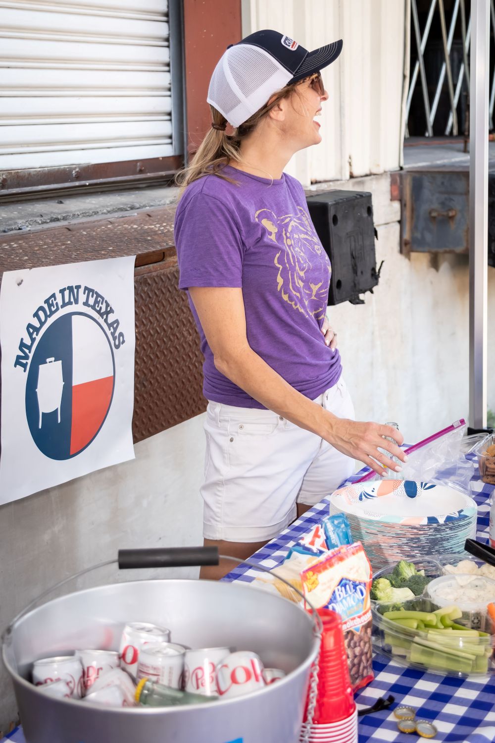 Person preparing food at a food stand with a 'Made in Texas' sign in the background